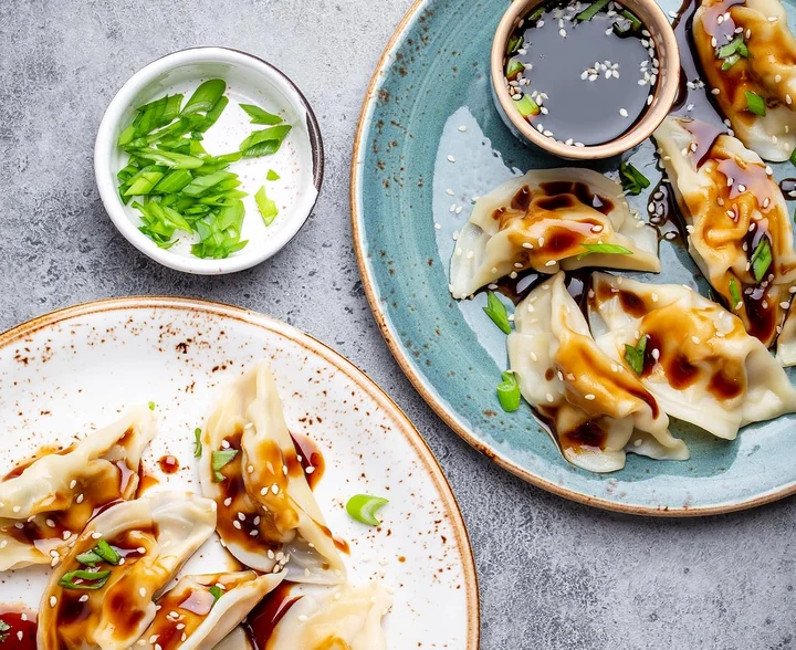 Pan-fried dumplings with a dark vinegar dipping bowl